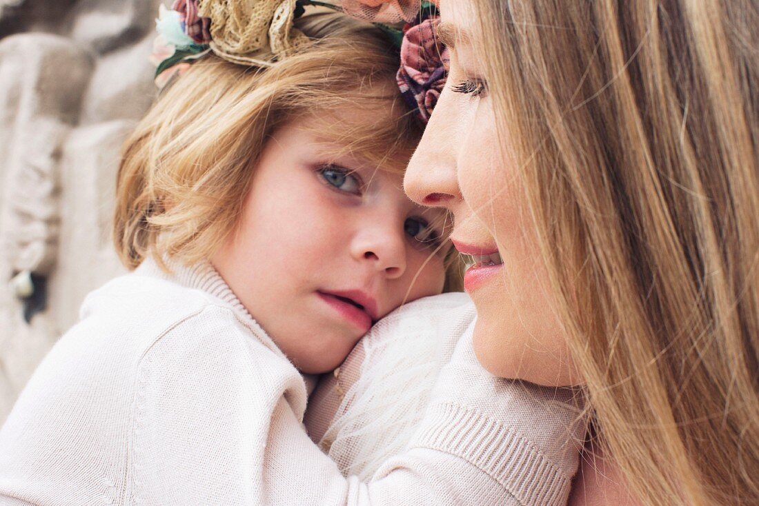 A close-up portrait of a mother and her young daughter