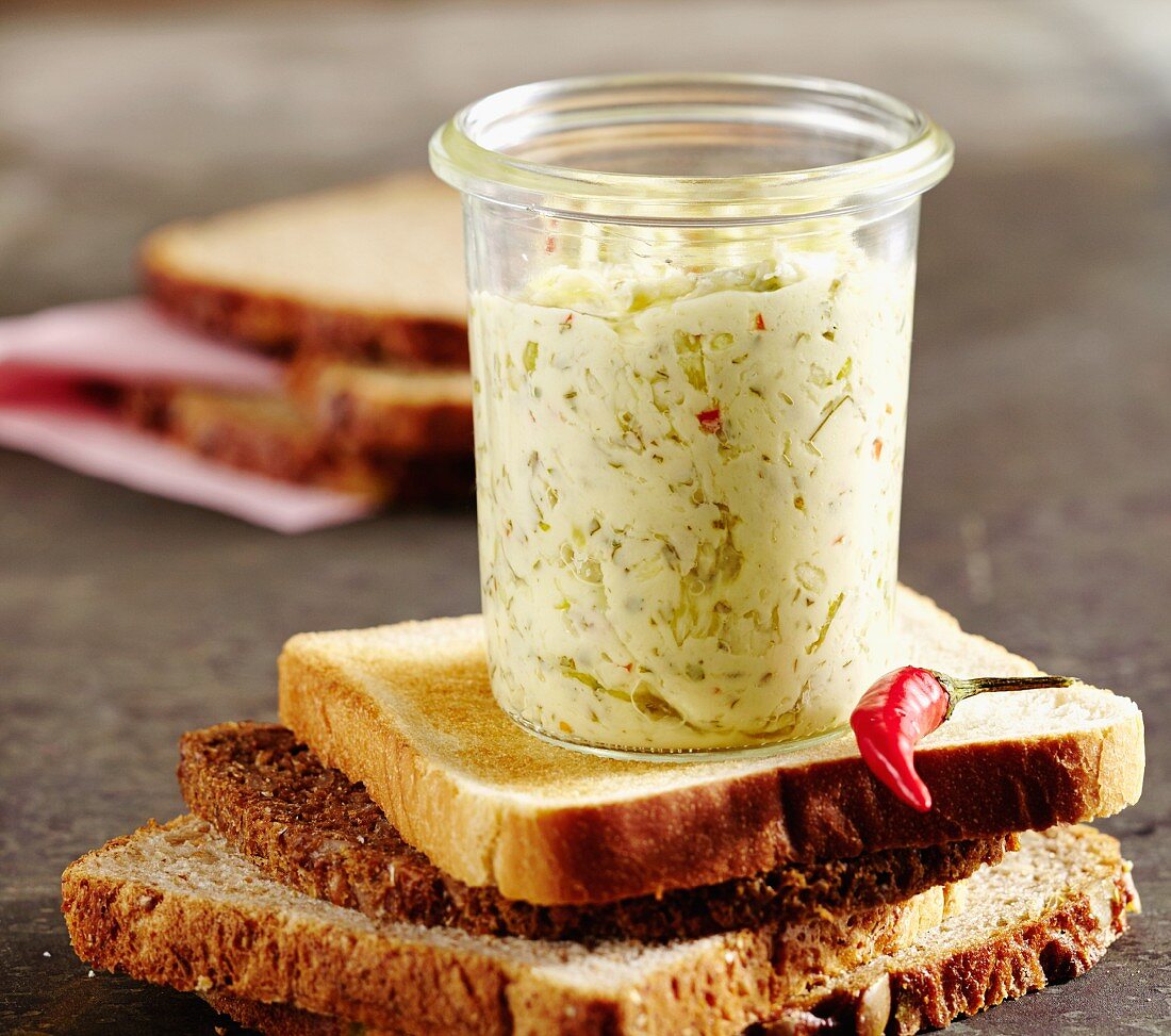 A jar of oriental chilli butter on a slice of bread