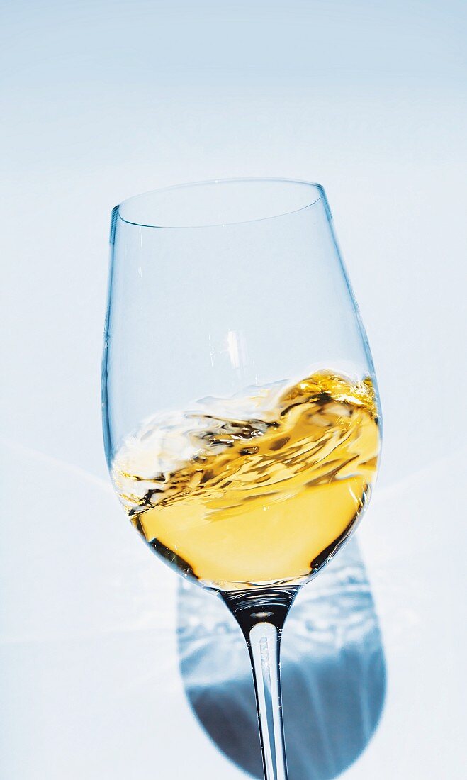 Weißwein schwappt im Glas