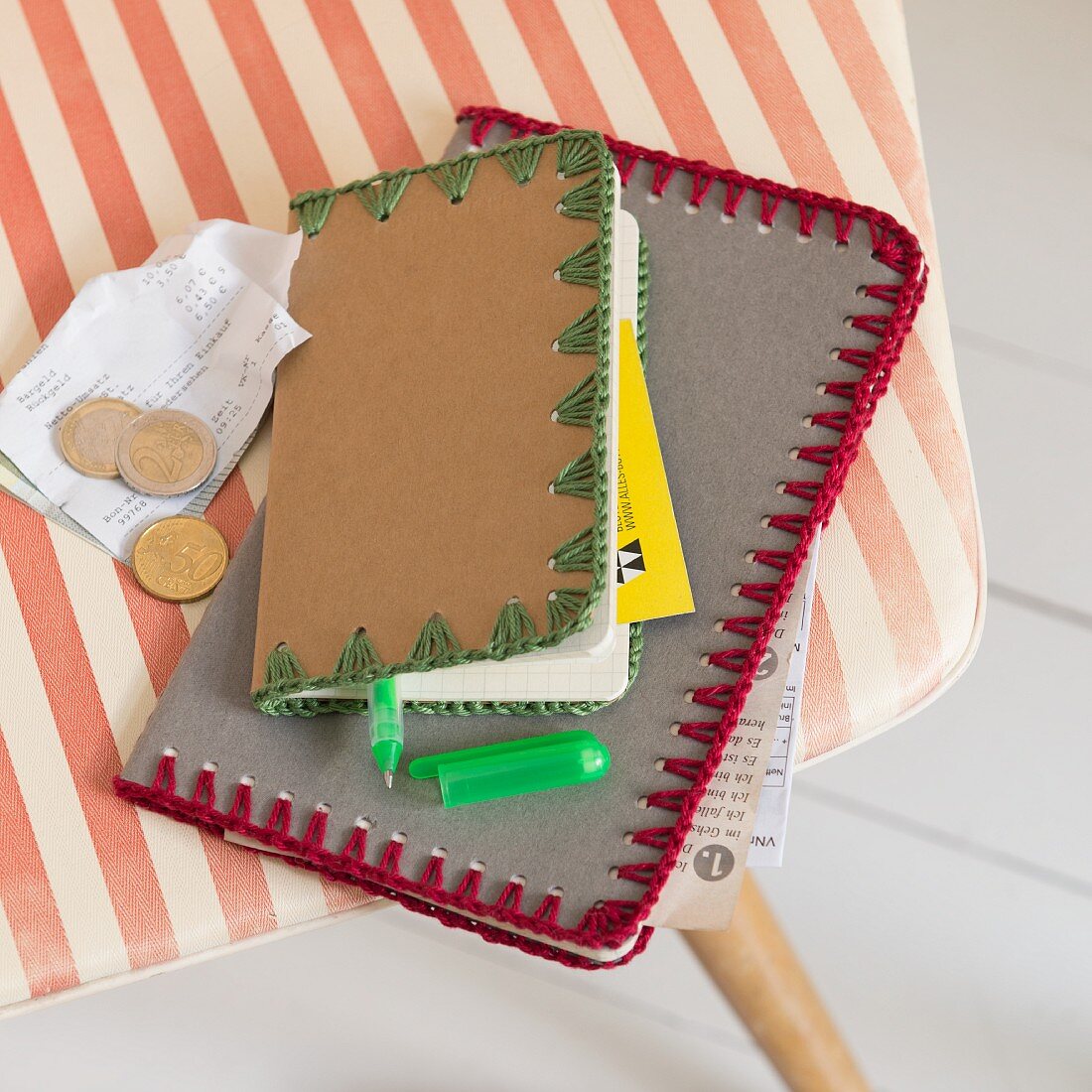 Notebooks with crocheted edging on a striped chair