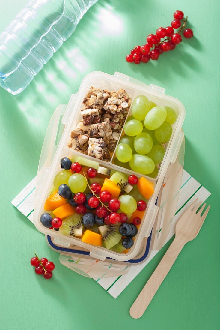 Lunchbox mit Obstsalat und Nussriegel