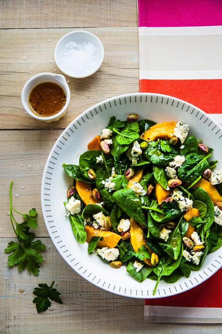 Spinach salad with poached quinces, blue cheese and pistachios