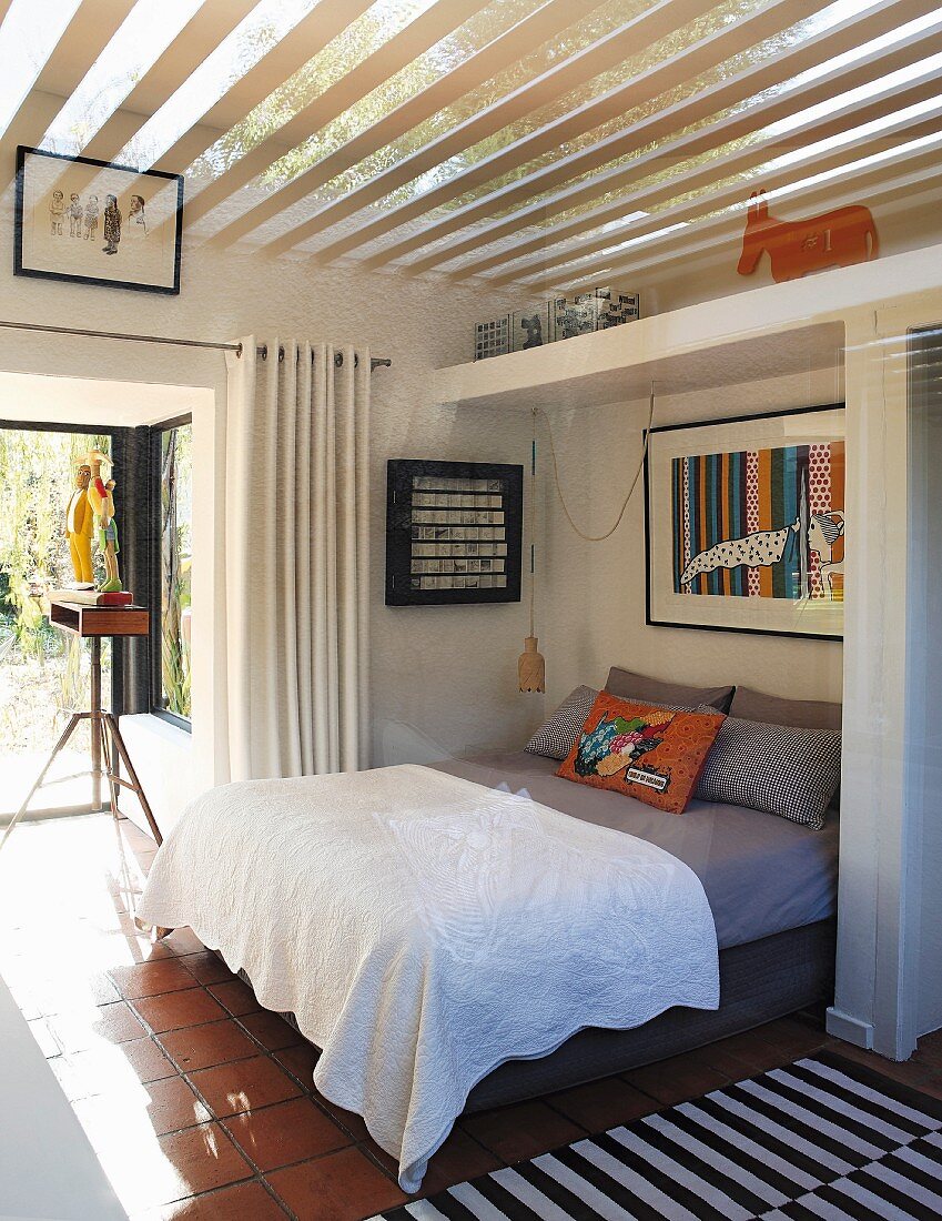 White bedspread on double bed in open-plan bedroom