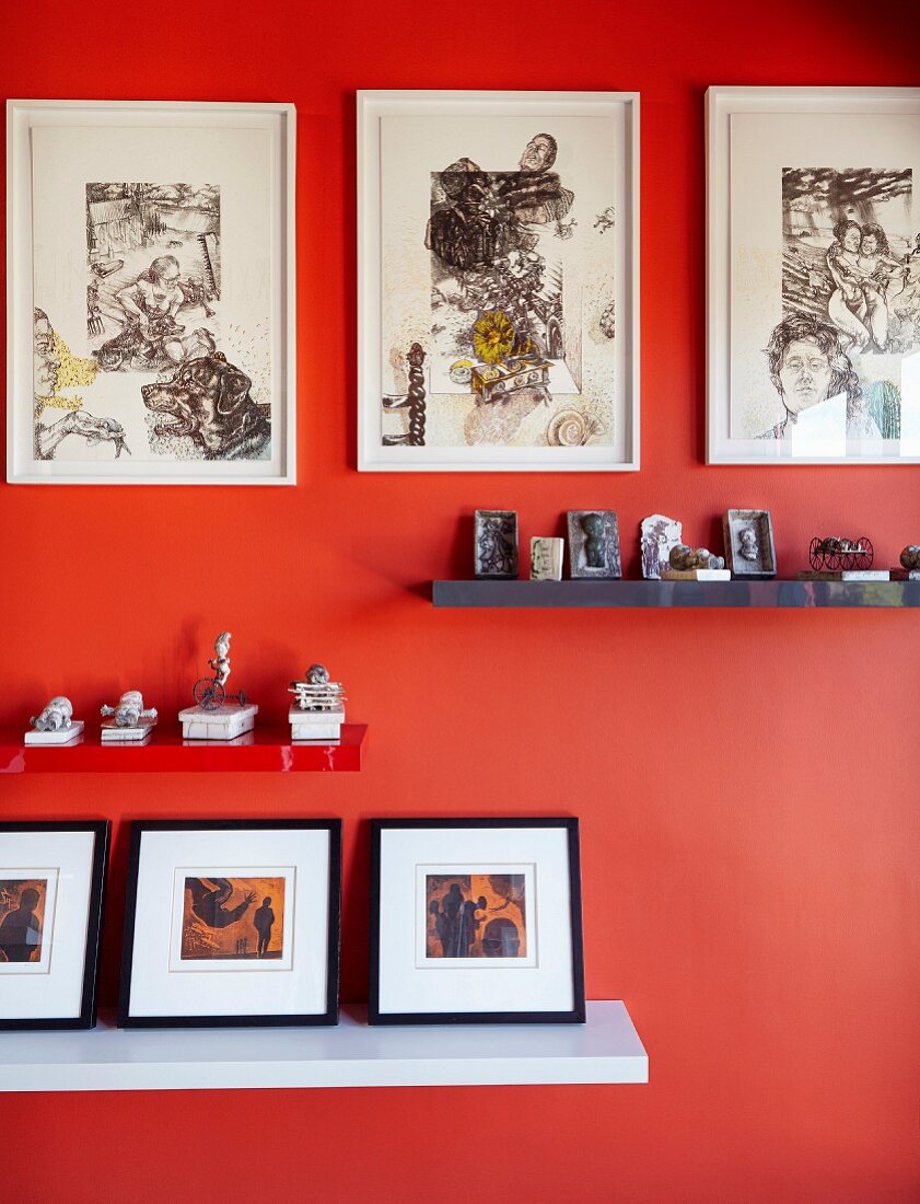 Regalablagen mit Sammlungen an orangefarbener Wand mit Bildergalerie