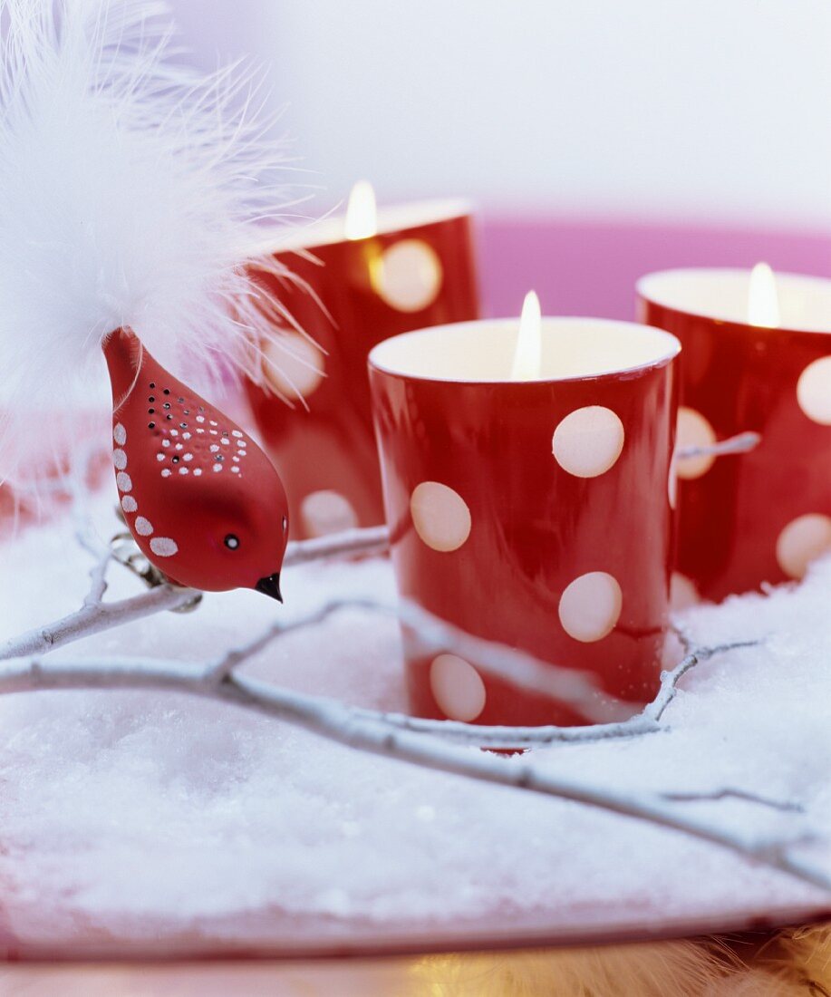 Red and white Christmas arrangement: red polka-dot tealight holders on artificial snow