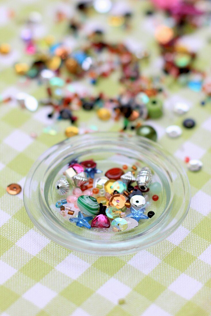 Various beads in and next to glass bowl