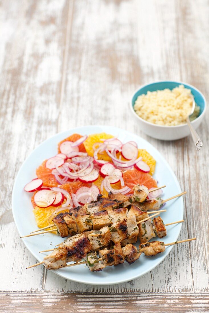 Pork skewers with a citrus fruit salad and couscous