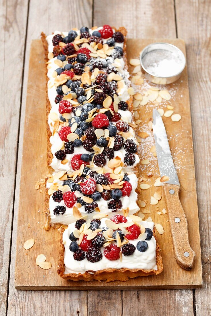 A tart topped with whipped cream and berries