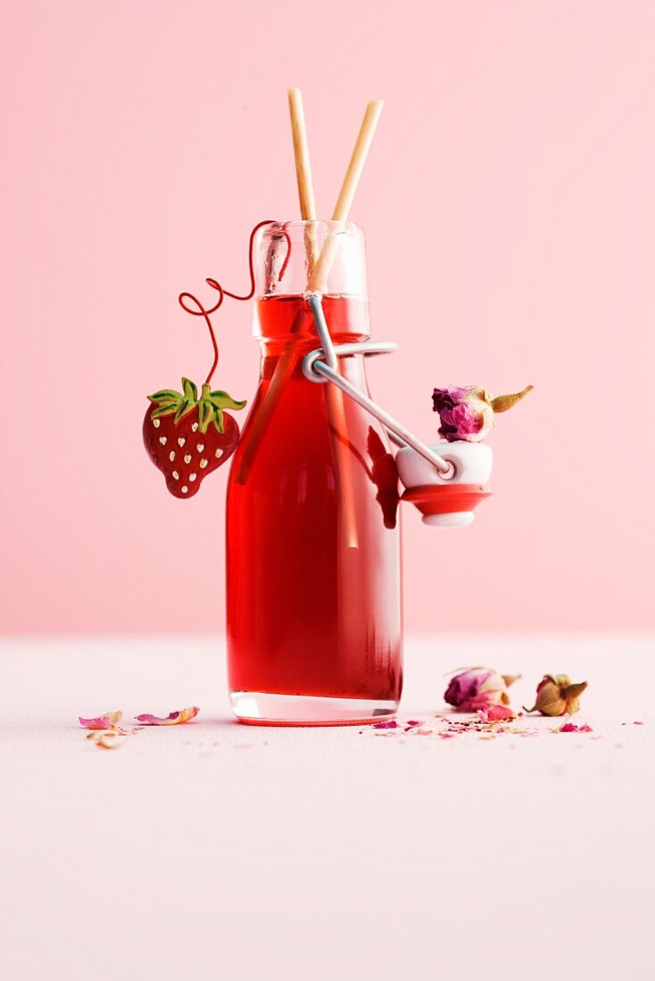 A bottle of homemade strawberry and rose syrup
