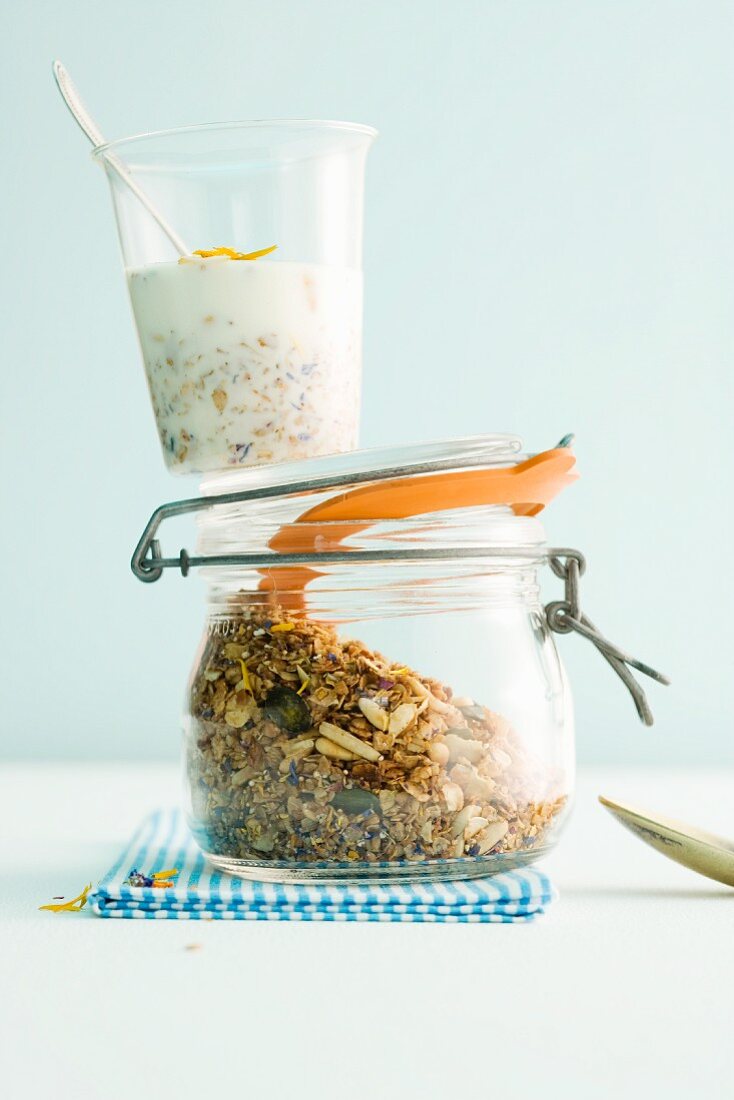 A cup of muesli on a jar of cereals