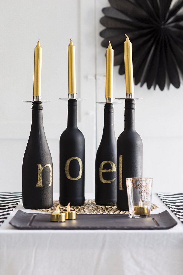 Four bottles used as candlesticks on Christmas table