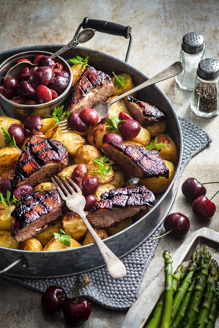 Duck breast with five spice powder on potatoes and cherries