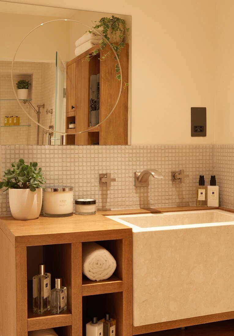 Wooden, custom washstand with integrated trough-style sink below square mirror with incised circle