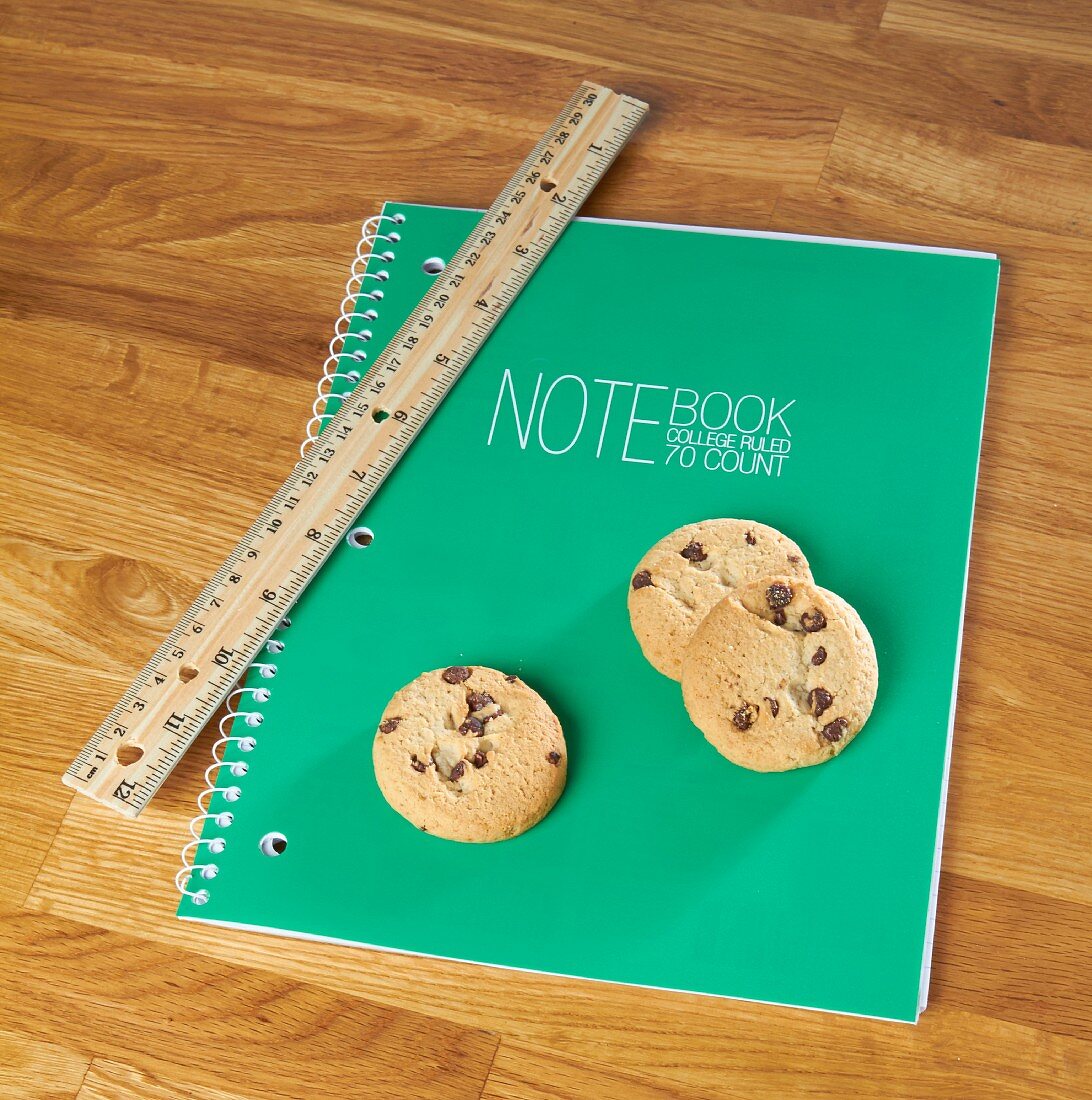 Chocolate chip cookies on a notebook with a ruler