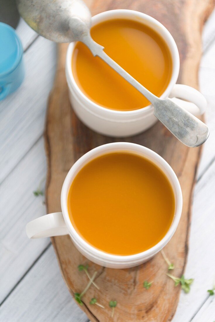 Butternusskürbissuppe in zwei Tassen (Draufsicht)