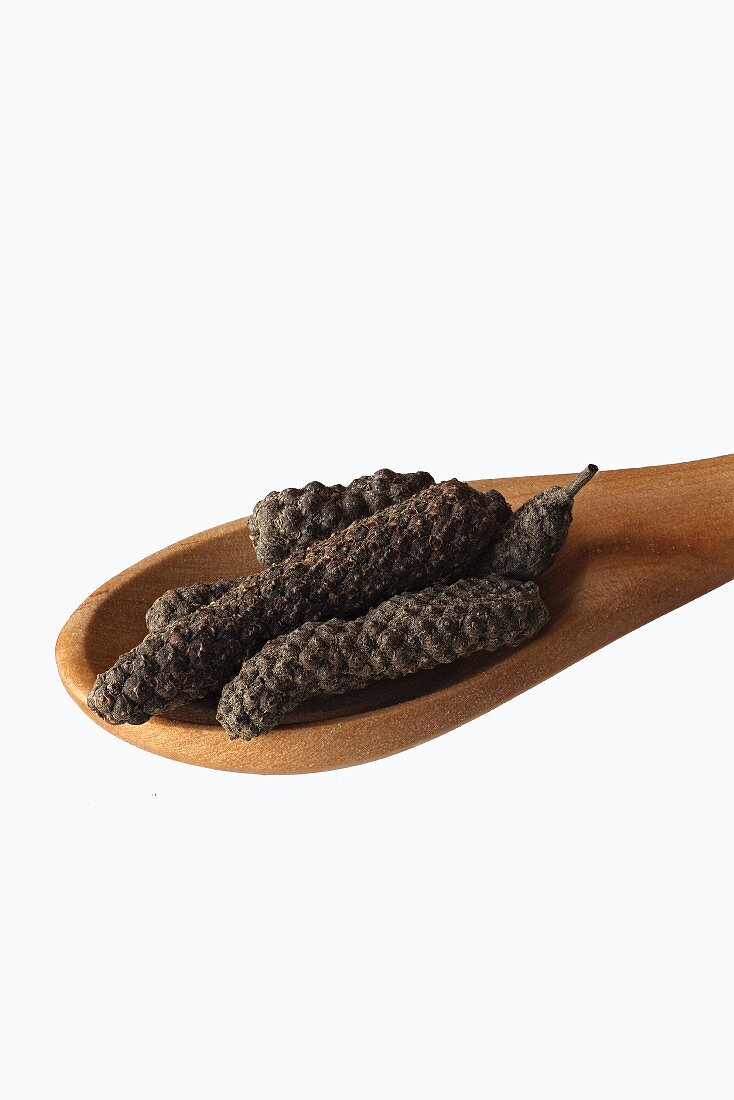 Pippali (long pepper) on a wooden spoon