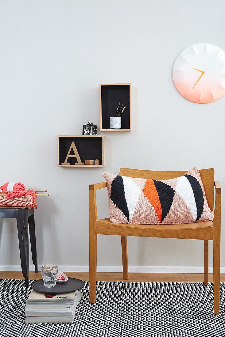 A cushion with knitted cover with a geometric pattern on a wooden chair