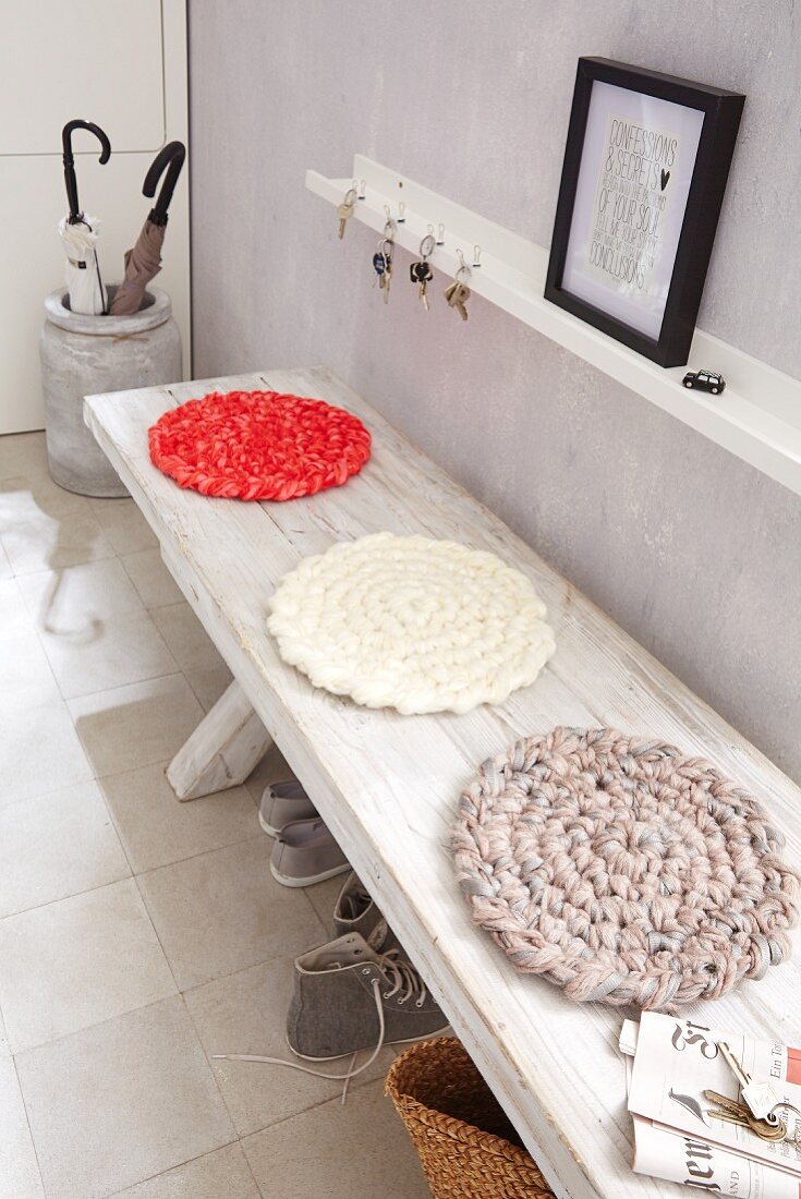 Homemade, round crocheted cushions on a wooden bank