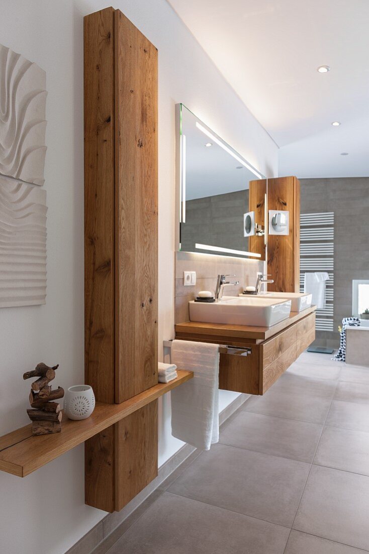 A made-to-measure wooden cupboard next to a washstand in a modern bathroom