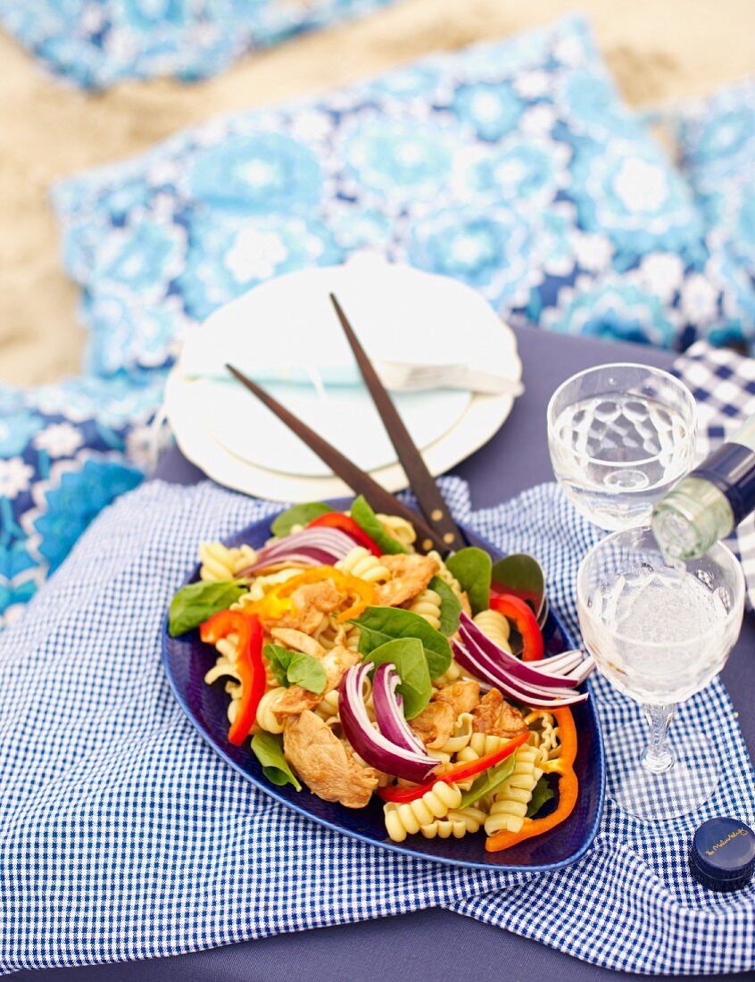 Pasta salad with chicken, pepper and spinach for a beach picnic