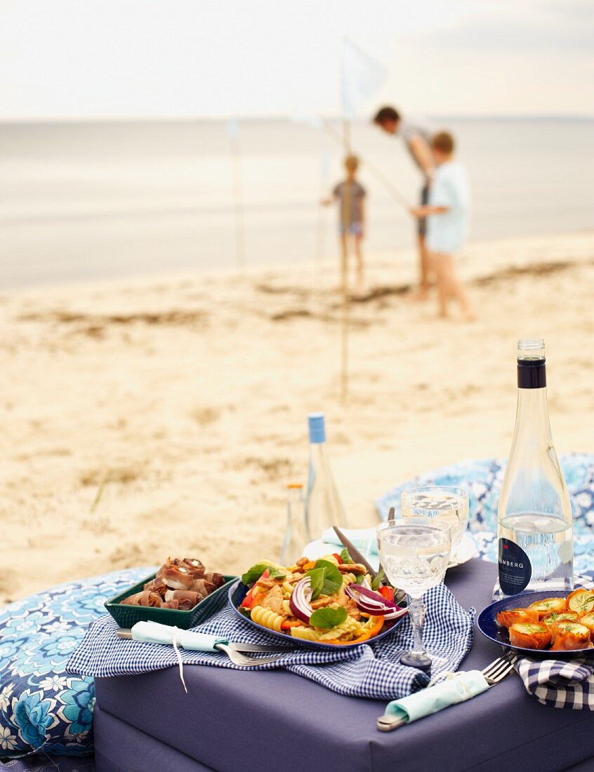 Strandpicknick mit Salat, Häppchen und Getränken