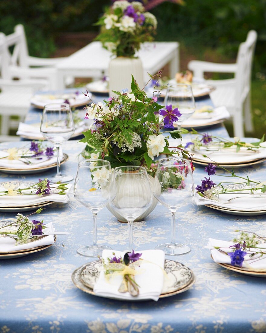 Gedeckter Gartentisch mit Wiesenblumen zum Mittsommerfest