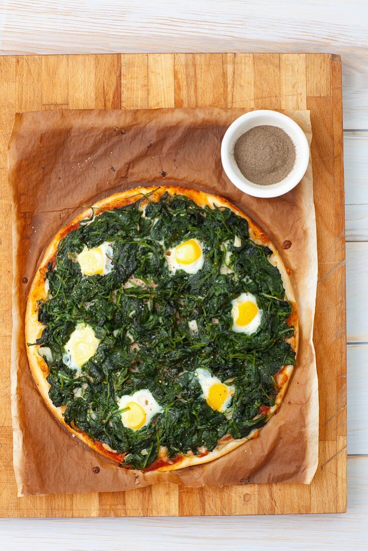 A pizza fiorentina with spinach and quail eggs