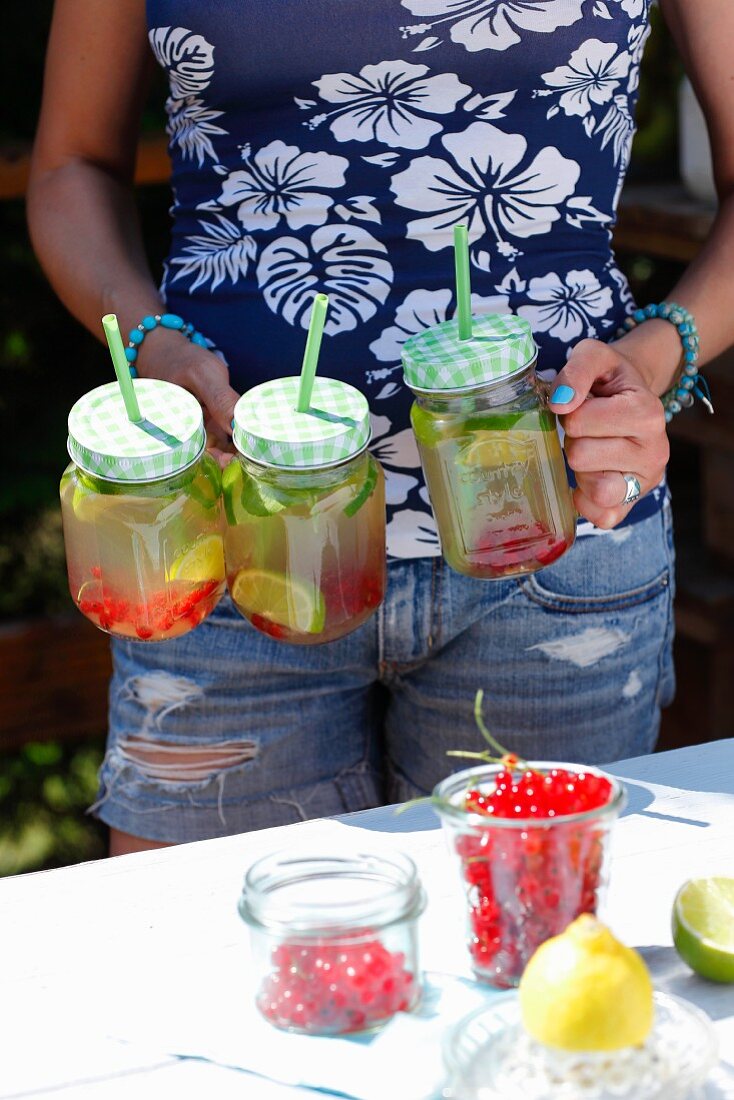 Frau trägt Gläser mit Limonade