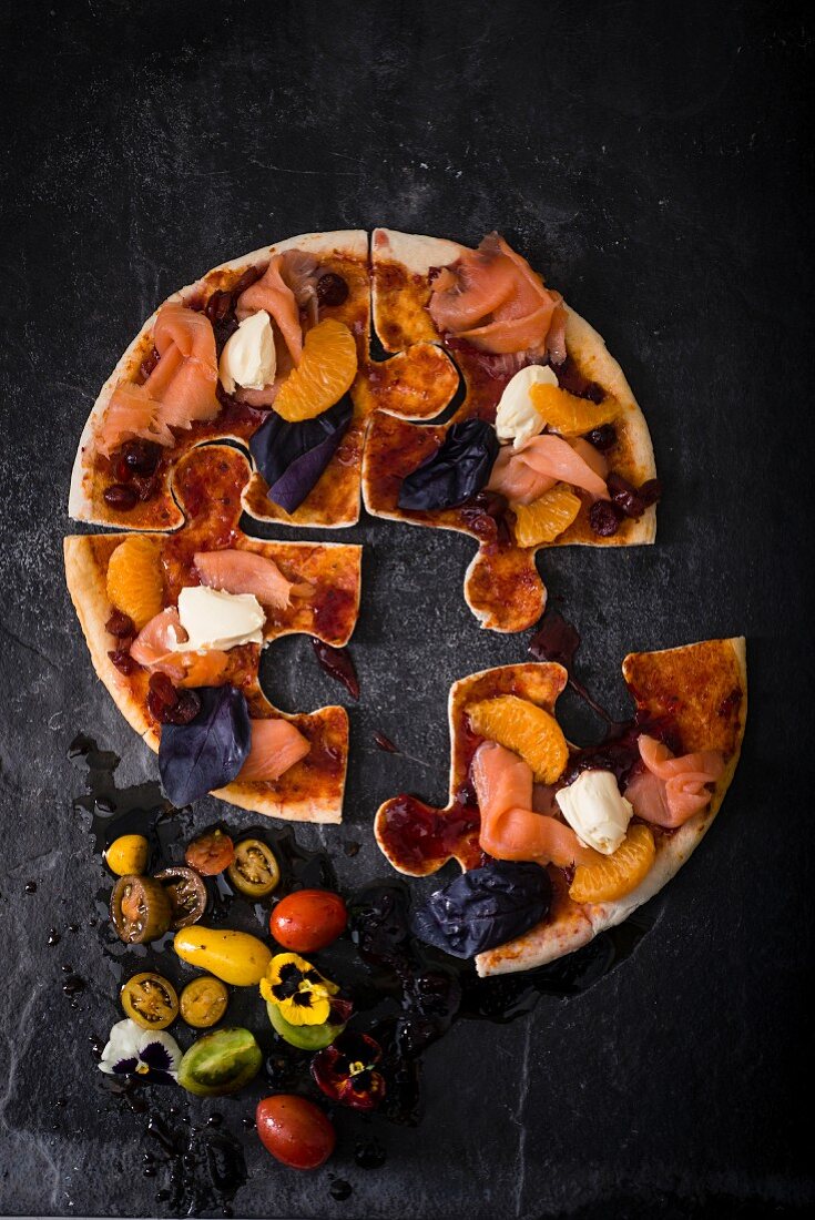 A pizza puzzle with smoked salmon and cranberry sauce