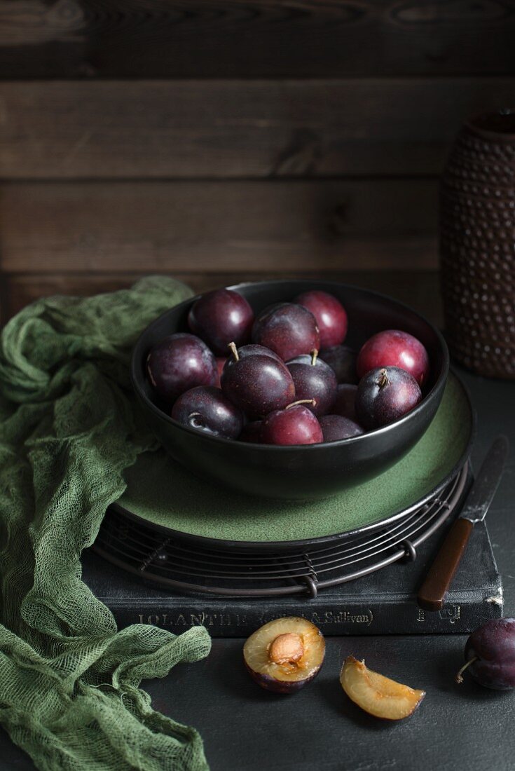 Fresh plums in a black bowl