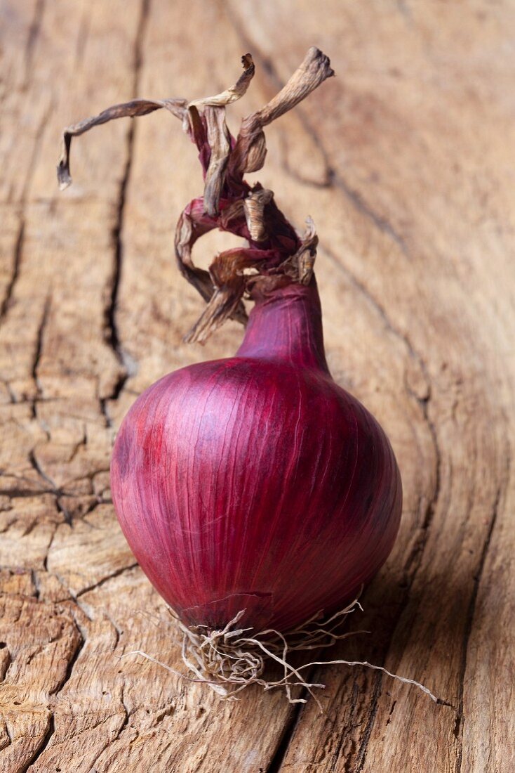 A red onion on a wooden surface