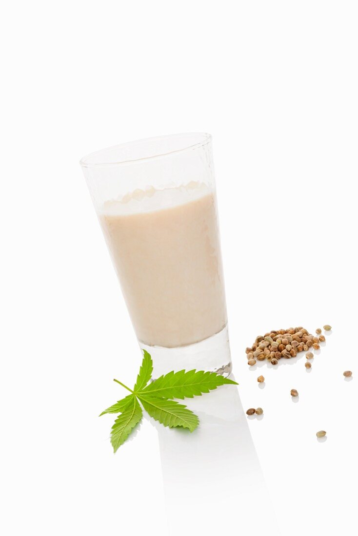 A glass of hemp milk on a white surface