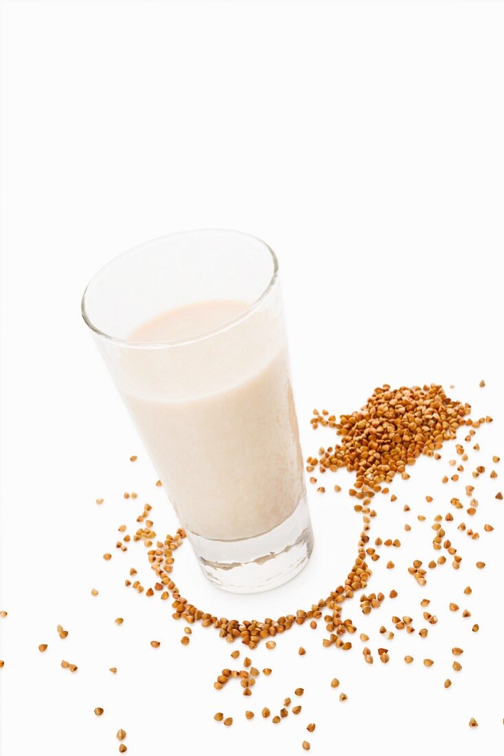 A glass of buckwheat milk on a white surface