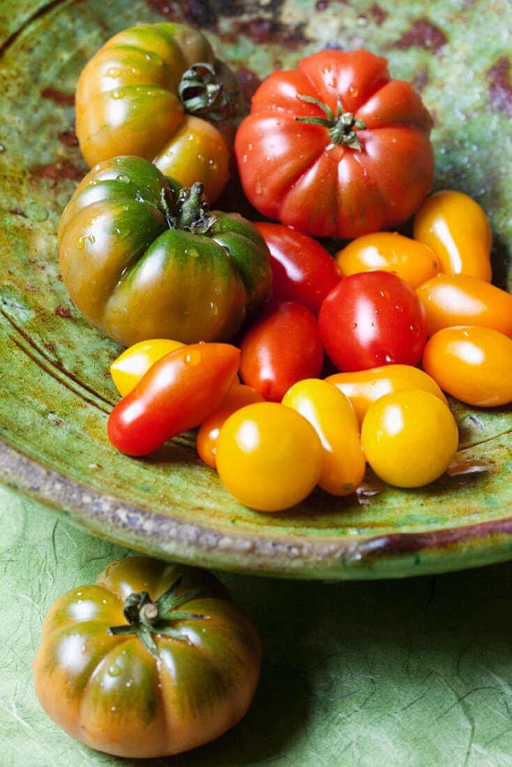 Various organic tomatoes in a ceramic bowl