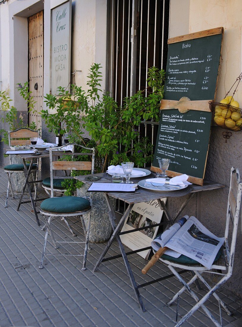 Bistro tables laid outside a cafe