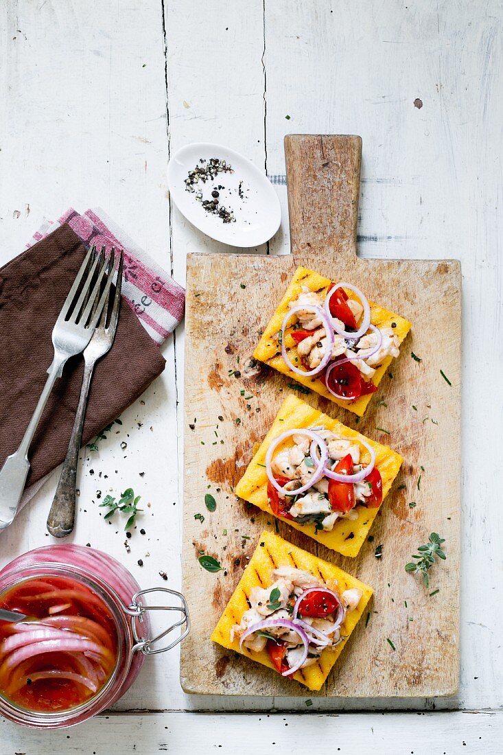 Polenta crostini with pickled red onions and fish