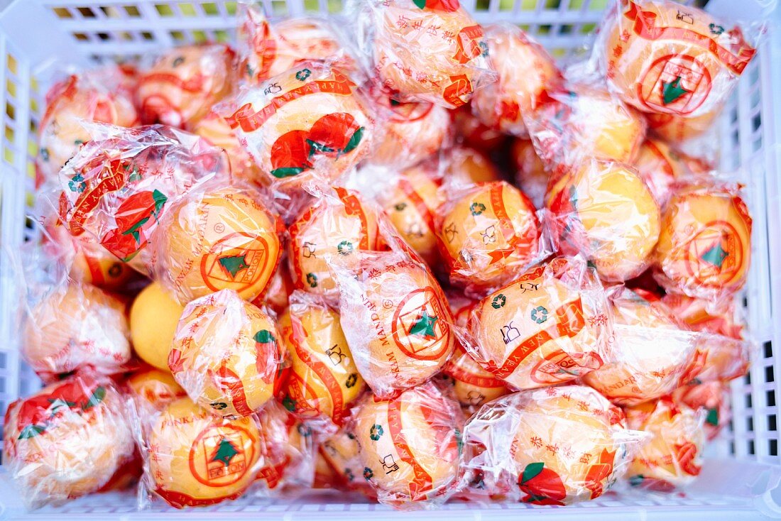 Oranges in cellophane in a crate (Bali)