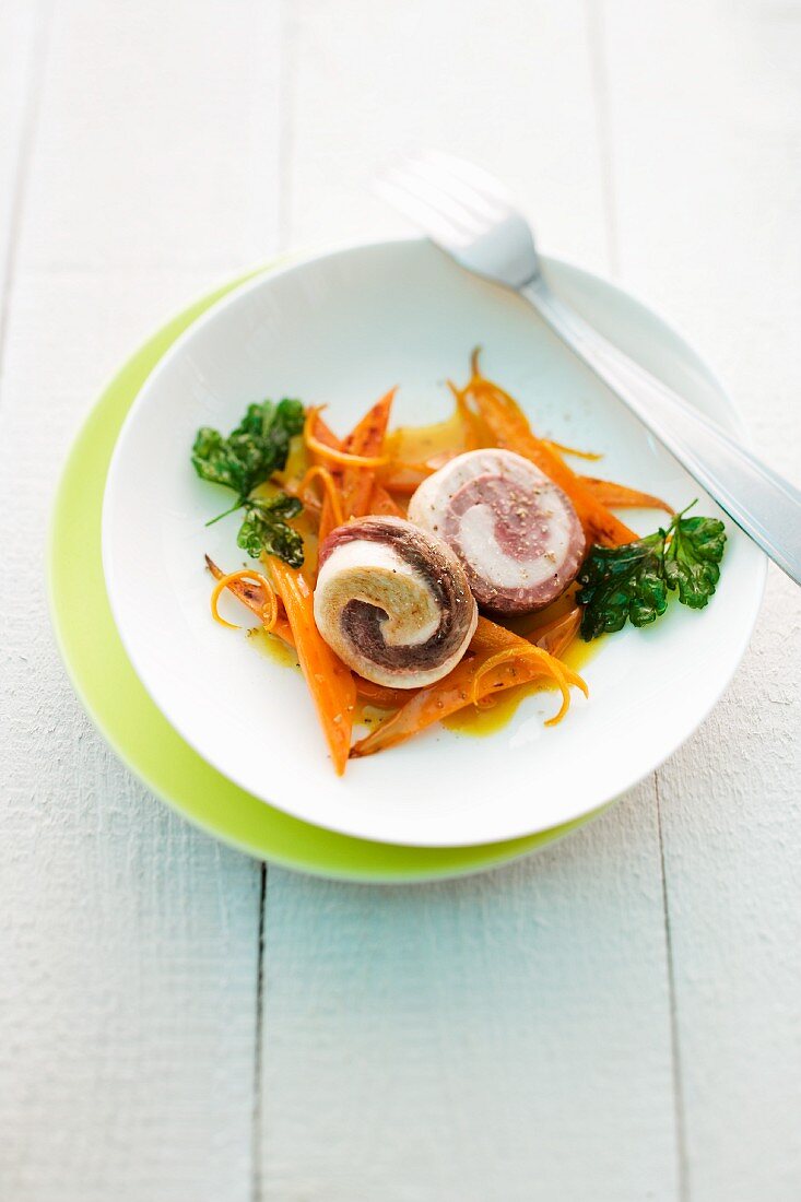 Duck and chicken rolls on a bed of vegetables
