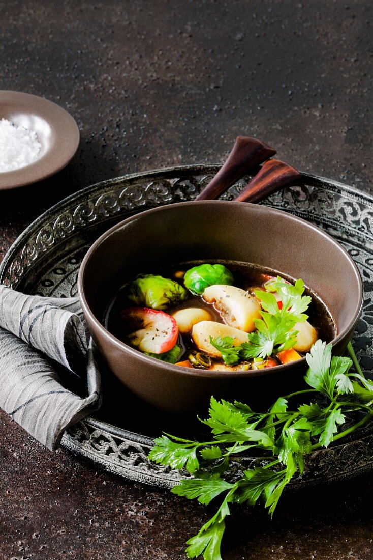 Stuffed dumpling soup with Brussels sprouts and baked apples