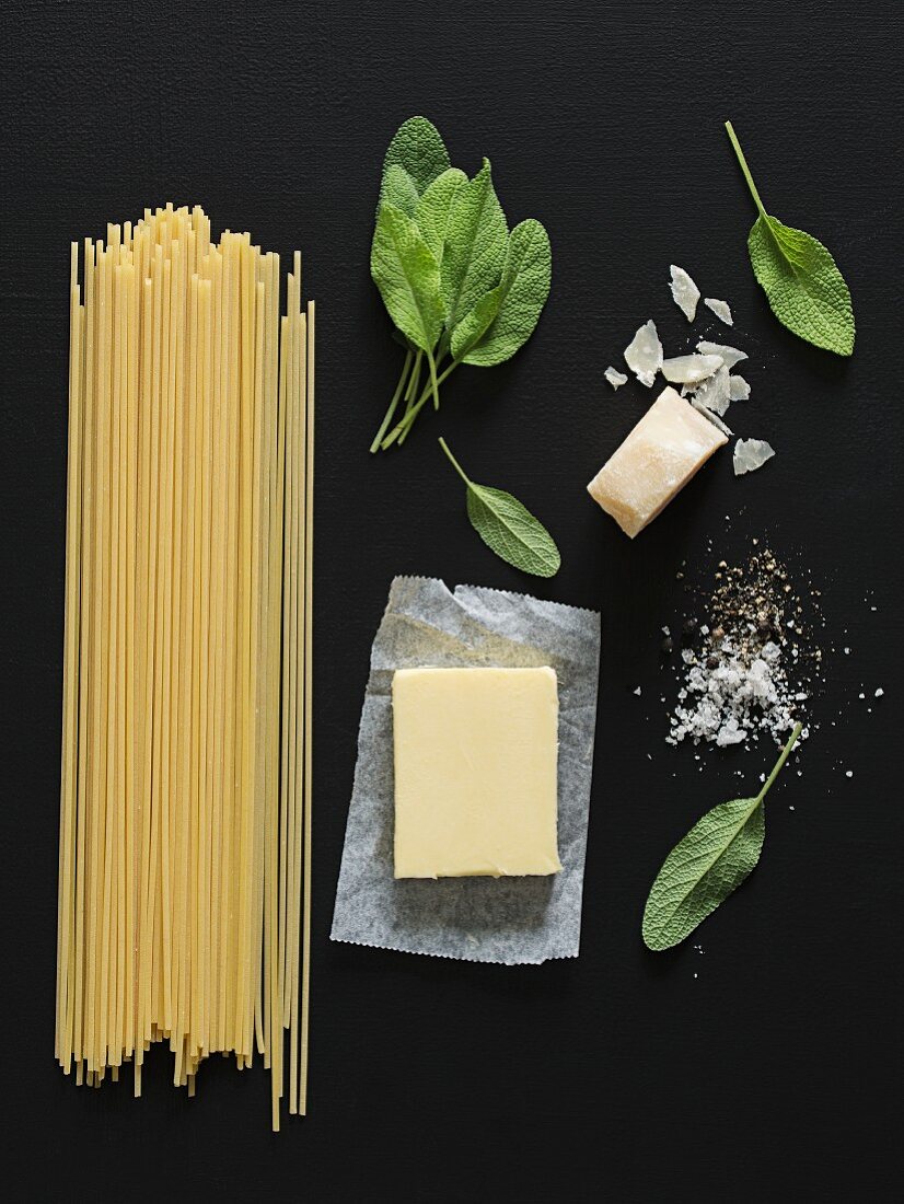 An arrangement of spaghetti, butter, sage and Parmesan cheese