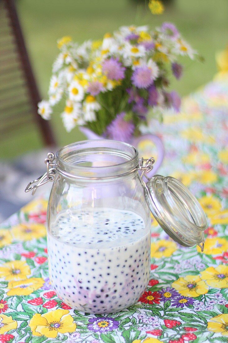 Blueberries in buttermilk in a preserving jar on a garden table
