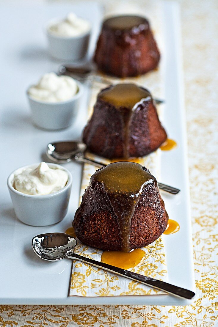 Three toffee puddings served with whipped cream