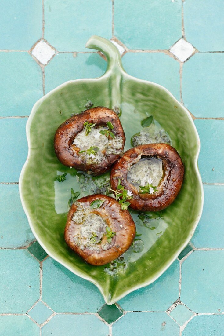 Grilled mushrooms with herb butter on a leaf-shaped plate