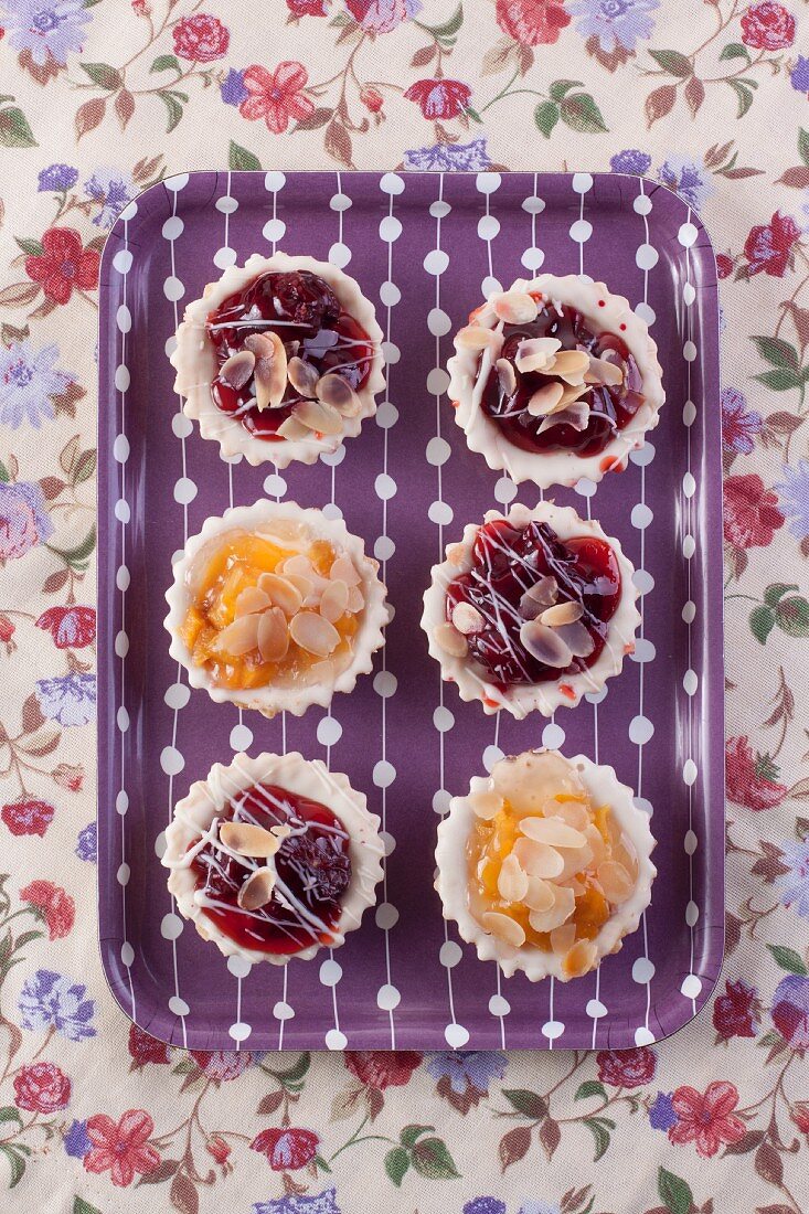 Cherry and peach tartlets on a tray (seen from above)