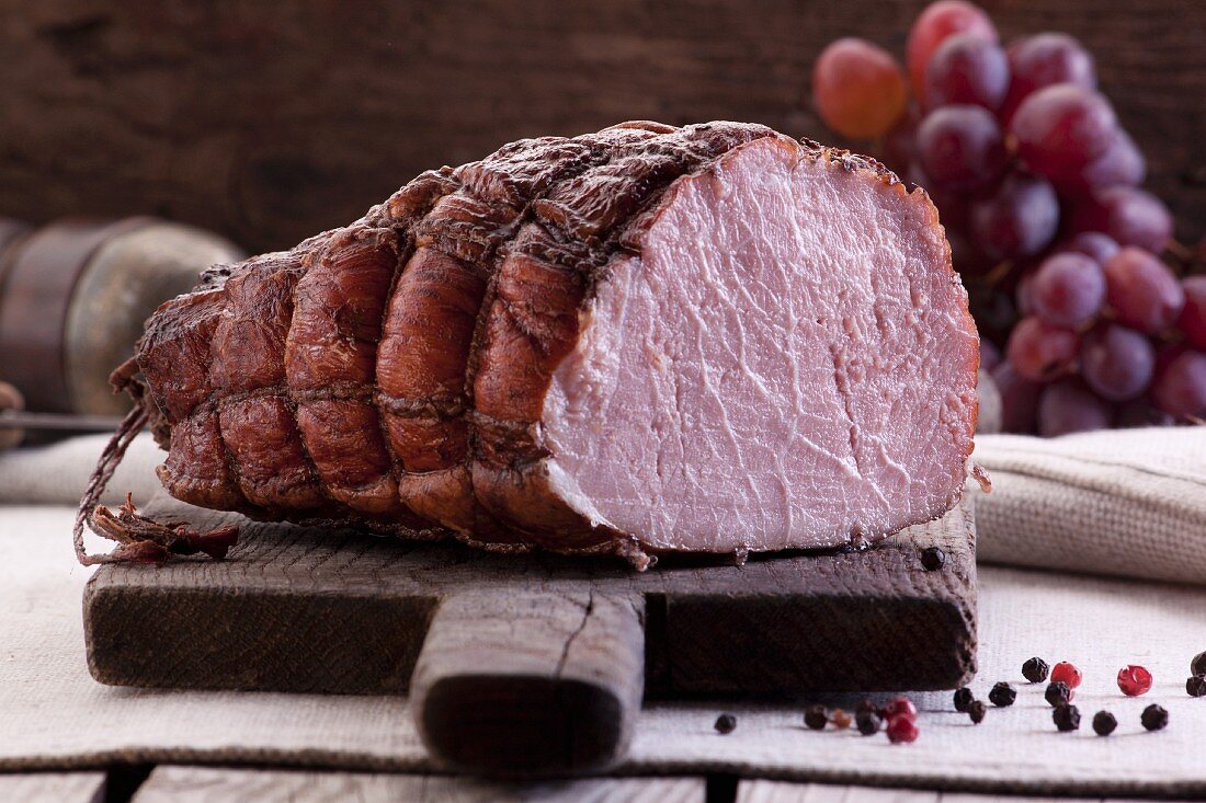 A whole smoked ham in a net