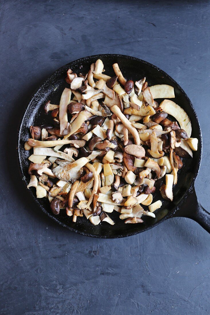 A pan on mixed mushrooms including king trumpet, piopinni, maitake, shiitake, oyster and matsutake mushrooms
