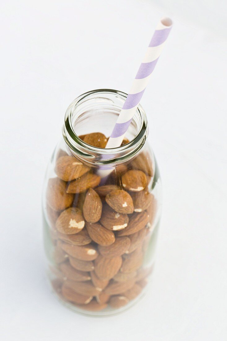 Almonds in a milk bottle with a straw