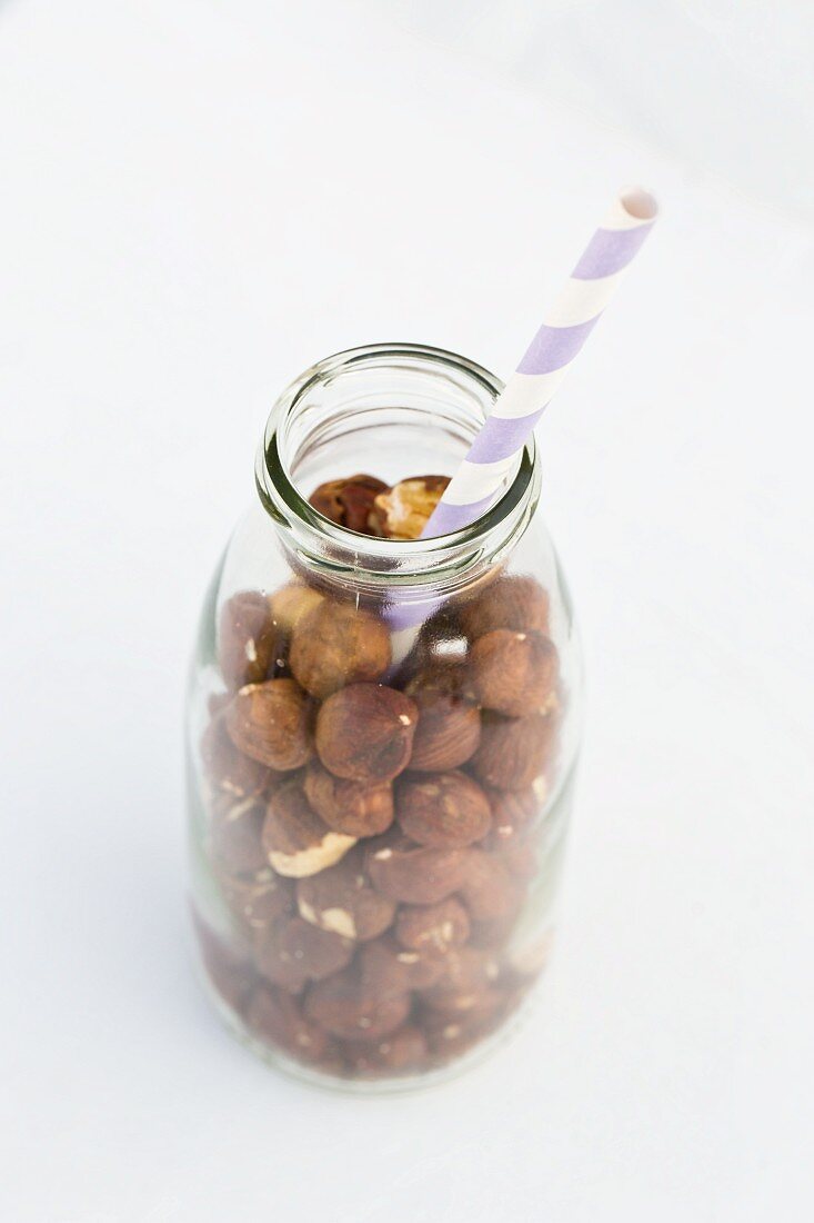 Hazelnuts in a milk bottle with a straw