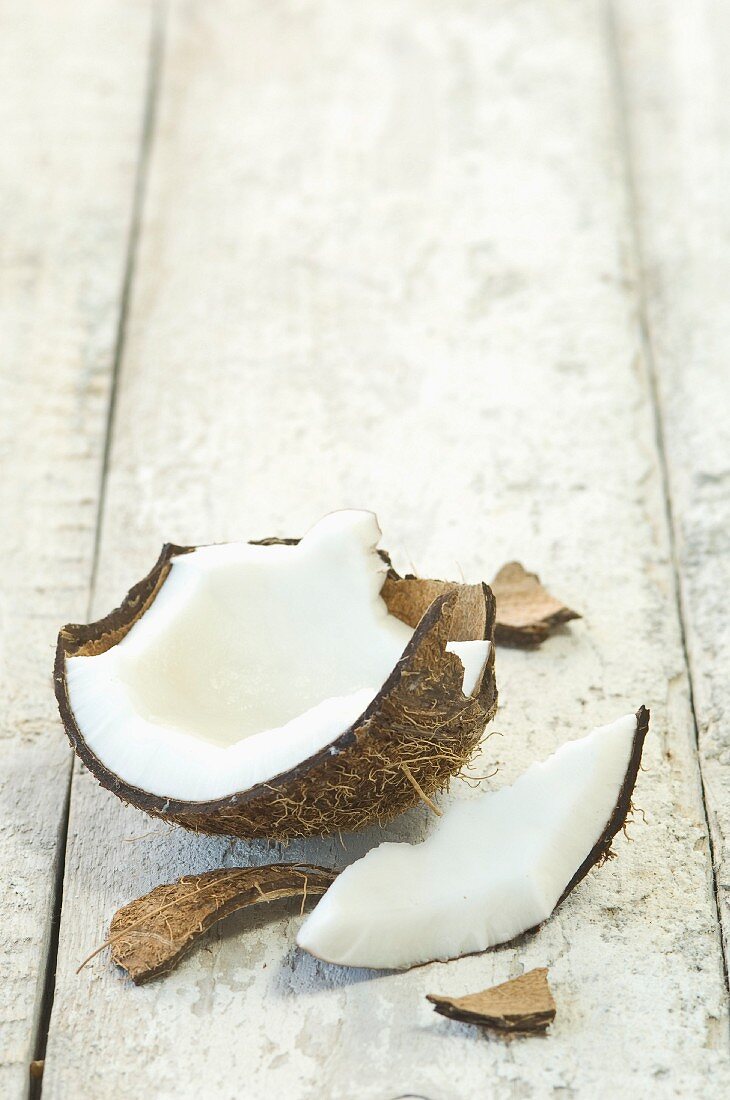 A broken coconut on a wooden surface