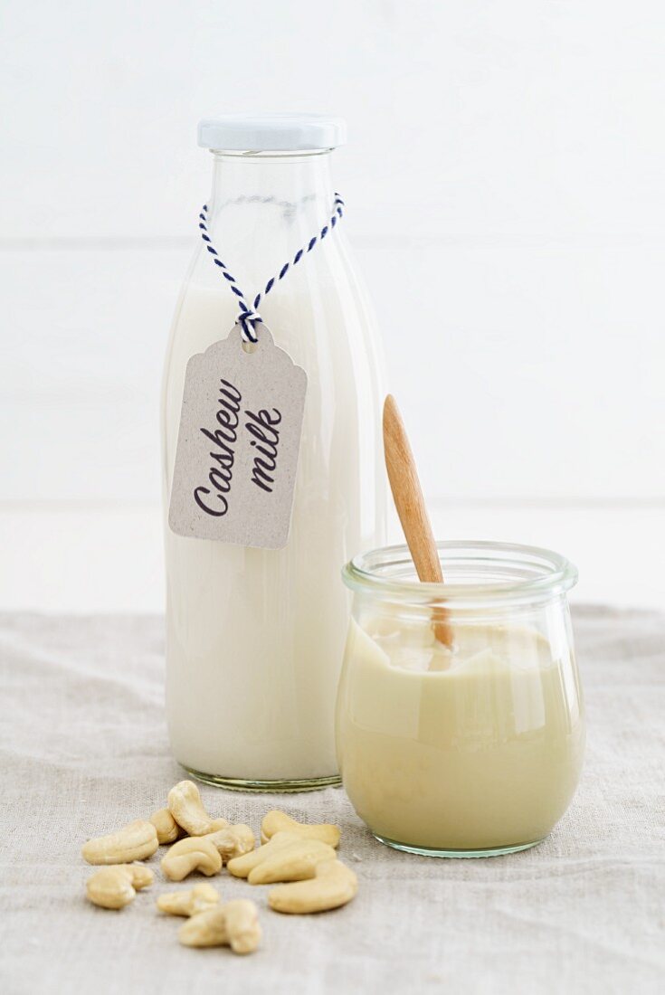 A jar of cashew nut mousse and cashew nut milk in a glass bottle